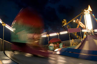 Colorful nighttime shot taken inside the tilt-a-whirl, carnival at night.