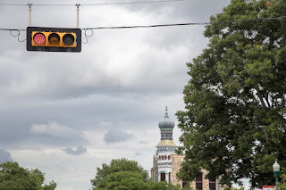A stoplight on the beautiful Georgetown, Texas square, showcasing an historic onion domed building in the backdrop