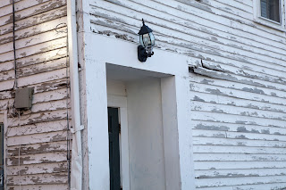 Crooked lamp on a house with peeling paint, in downtown Portsmouth, New Hampshire