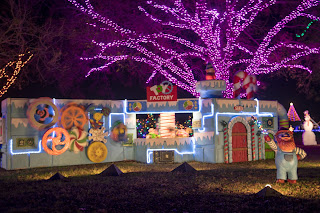 An image of a brightly lit holiday light display featuring a toy factory setup, in Austin, Texas at the Trail of Lights 