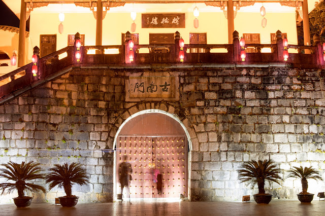 Mysterious figure standing at a gate in Guilin, China. Nighttime image with colored lights. 