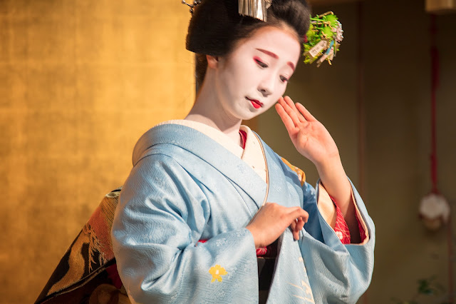 Portrait of a Maiko in traditional Kimono dress performing dance in Kyoto, Japan 