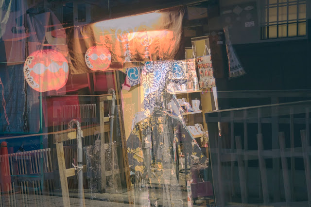 Shop window in Gion, Kyoto, Japan featuring a Kimono for sale and hanging lanterns, taken at night