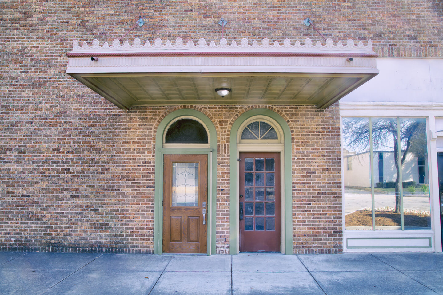 Two doors under an overhang mark the entrance to an historic building in downtown Taylor, Texas, USA 