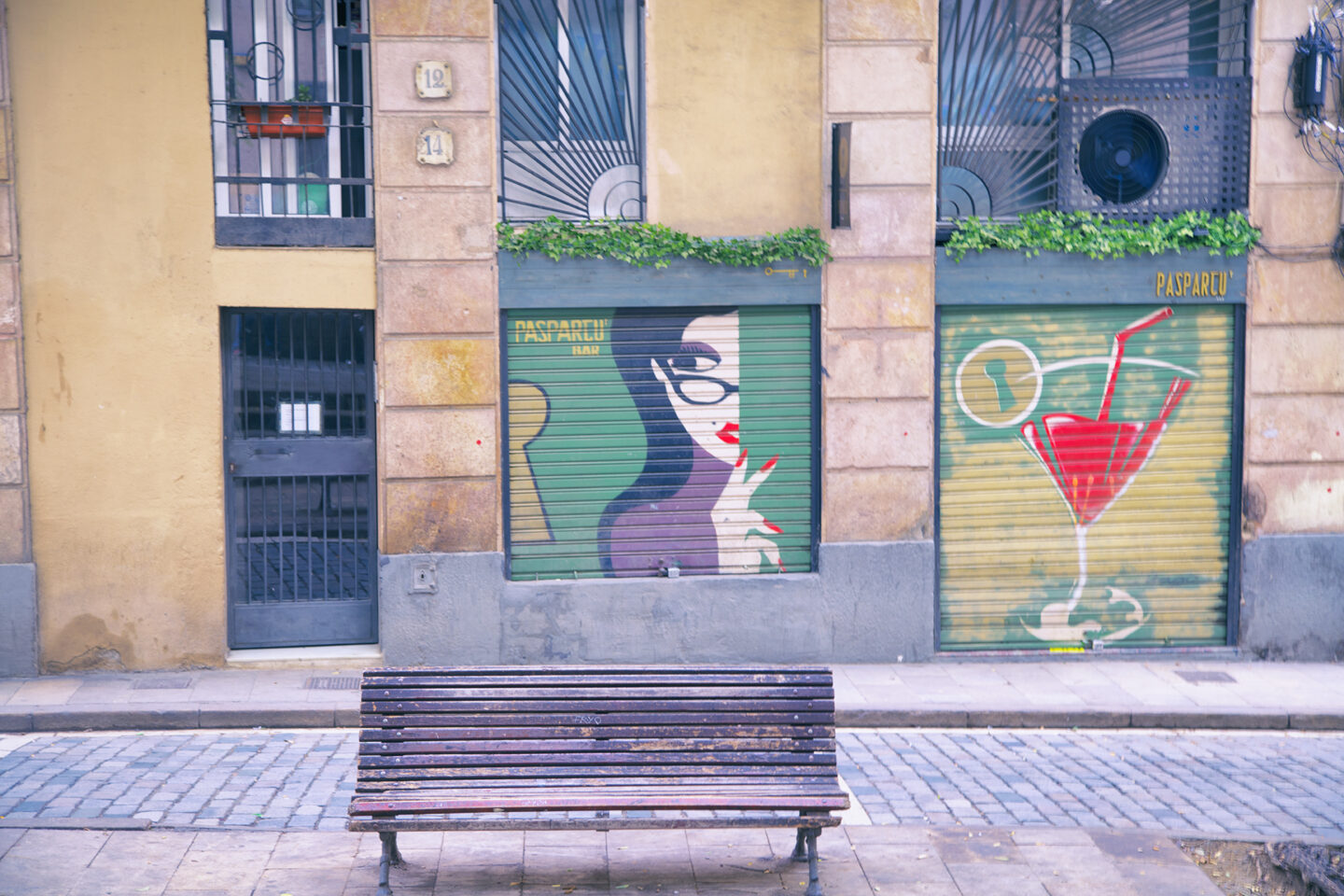 Street art in the Gothic Quarter of beautiful Barcelona, Spain featuring mural of a lady with eyeglasses and a giant martini glass