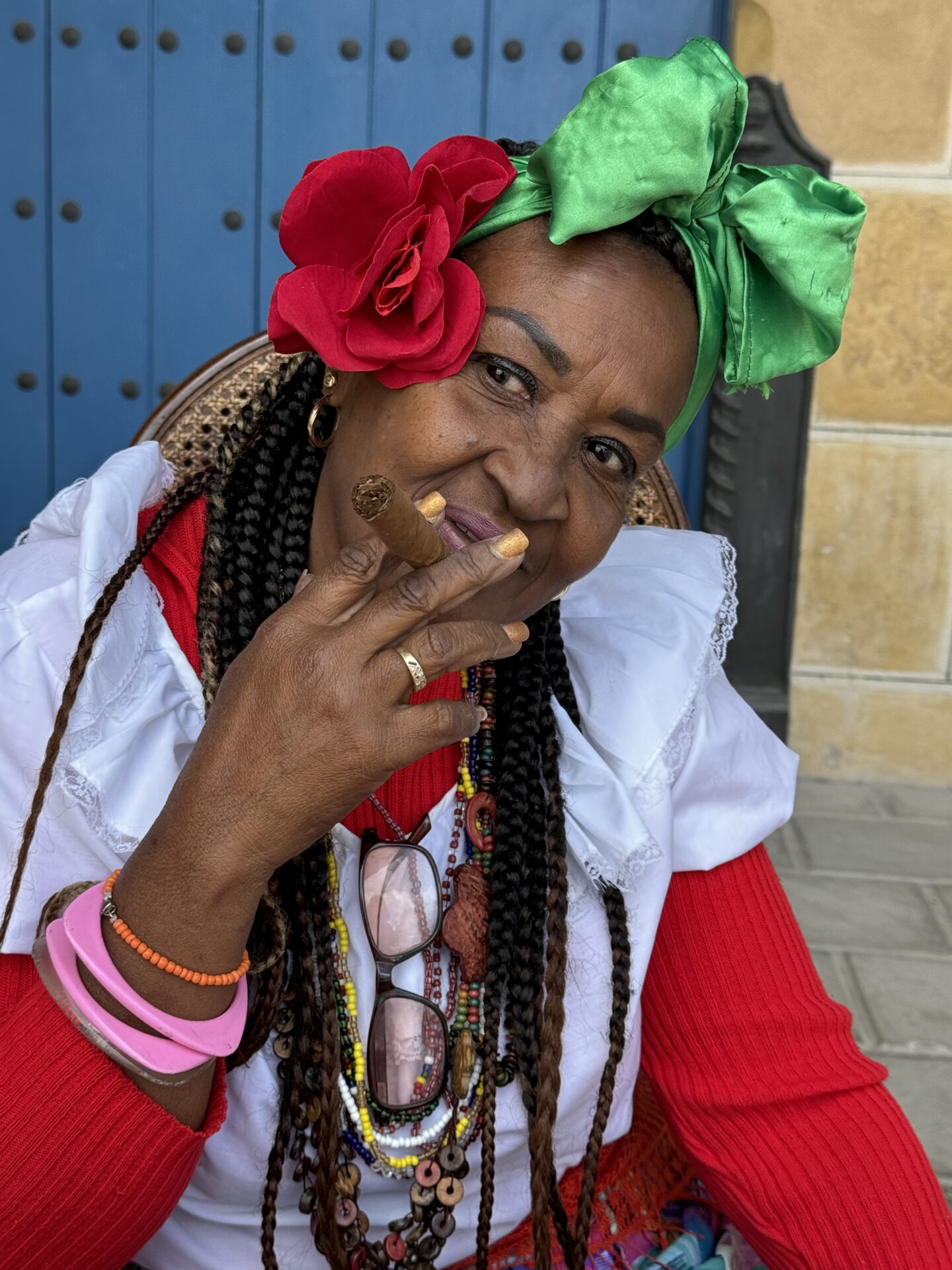 Street style portrait of a woman in traditional dress from Havana, Cuba, holding a cigar, as taken by Carol Schiraldi of Carol's Little World 