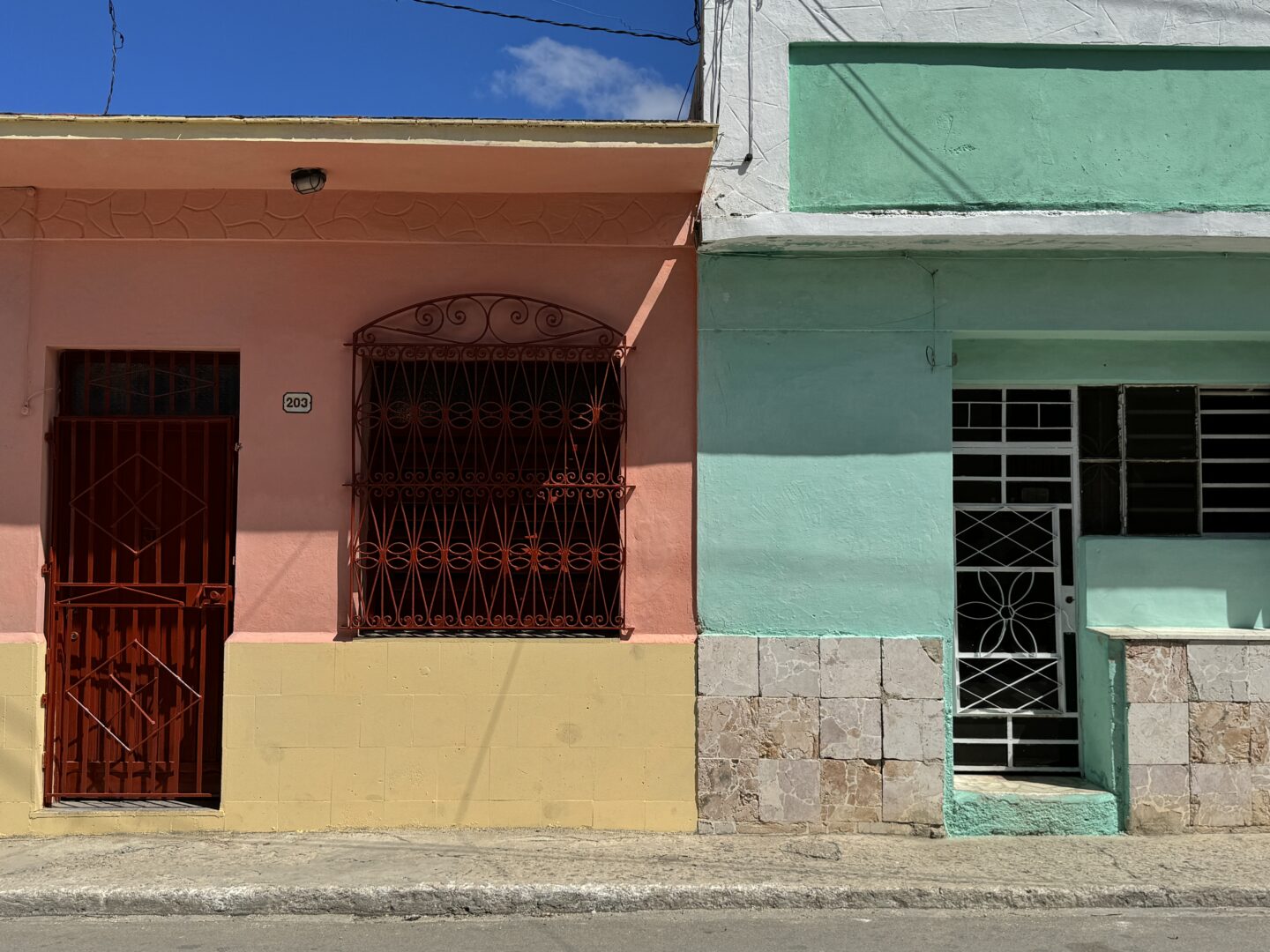 View of Regla town in Havana, Cuba featuring a colorful facade and entryways for local houses by Carol Schiraldi of Carol's Little World for Opportunity List. 
